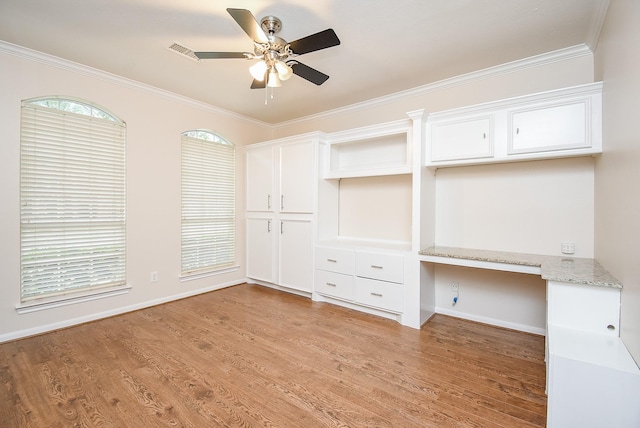 interior space featuring light hardwood / wood-style flooring, built in desk, ornamental molding, and ceiling fan