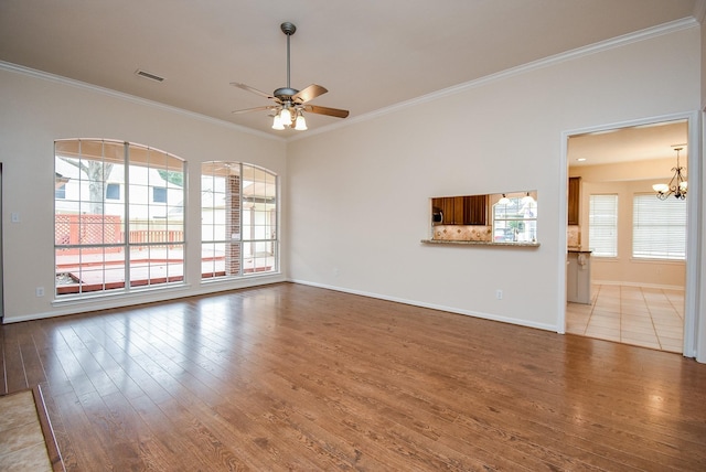 unfurnished living room with hardwood / wood-style flooring, crown molding, and ceiling fan with notable chandelier