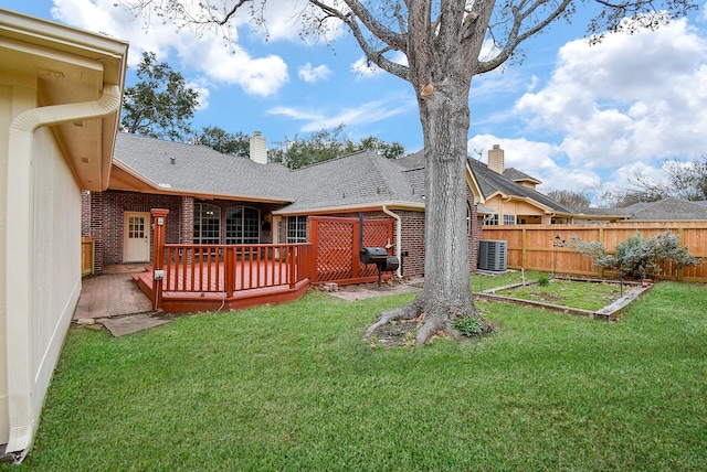 back of property featuring a wooden deck, cooling unit, and a lawn