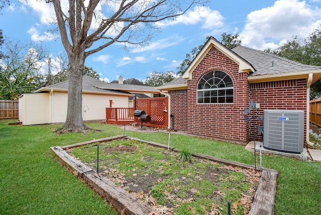 back of house with a wooden deck, a yard, and central AC