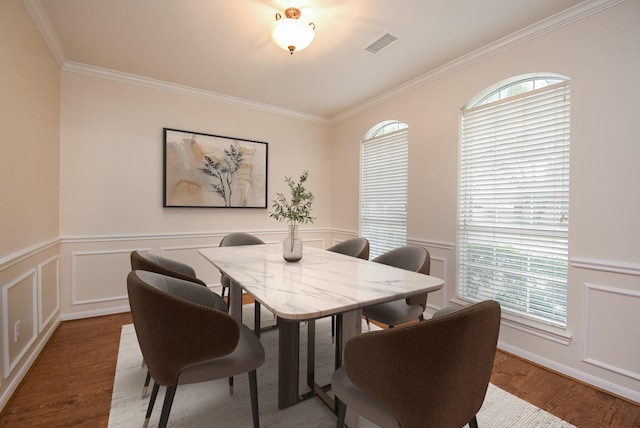 dining area featuring crown molding and hardwood / wood-style floors