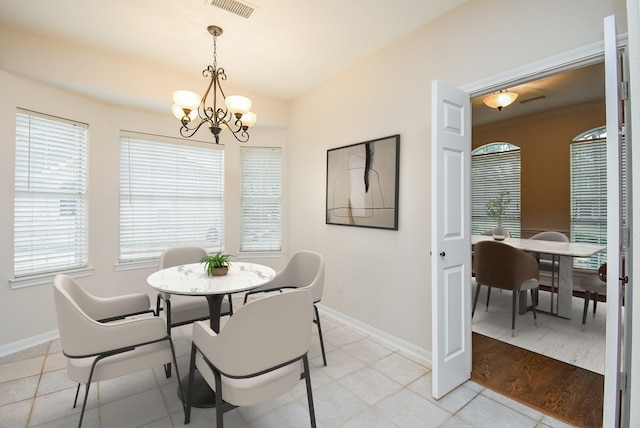 tiled dining space with an inviting chandelier