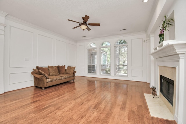 living room featuring a fireplace, light hardwood / wood-style flooring, and ornamental molding