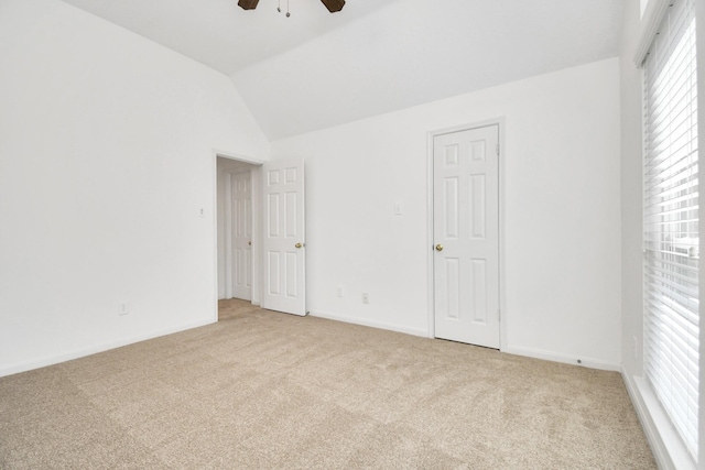 carpeted empty room with ceiling fan and vaulted ceiling