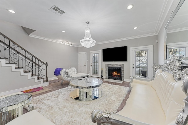 living room with hardwood / wood-style flooring, ornamental molding, and a fireplace