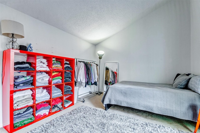 bedroom with lofted ceiling, carpet floors, and a textured ceiling