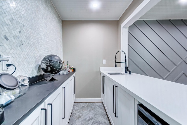 interior space with white cabinets, sink, and light parquet floors