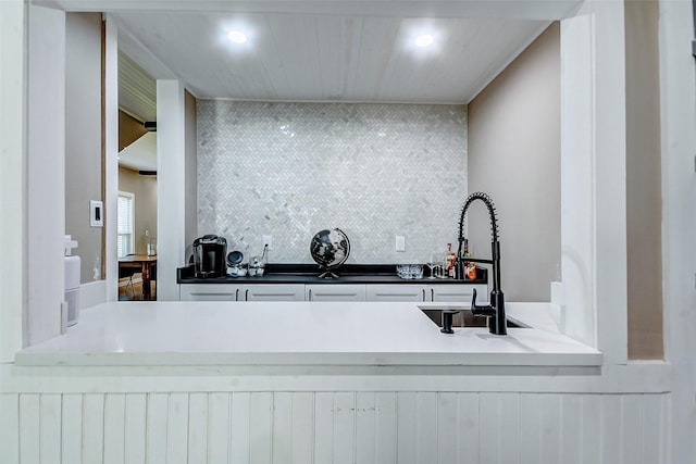 kitchen featuring decorative backsplash, sink, and white cabinets