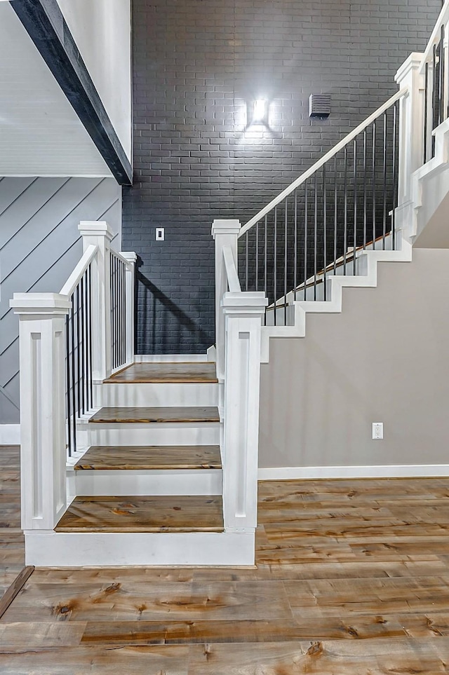 stairs with a towering ceiling and wood-type flooring