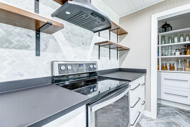 kitchen featuring black electric range oven, white cabinets, and island exhaust hood