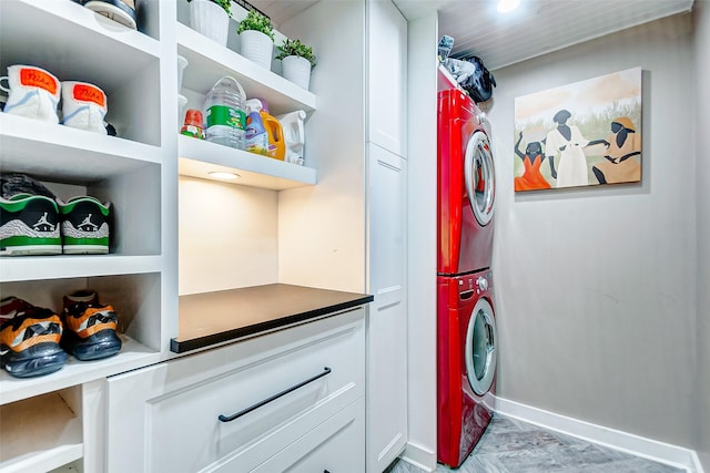 clothes washing area featuring cabinets and stacked washing maching and dryer