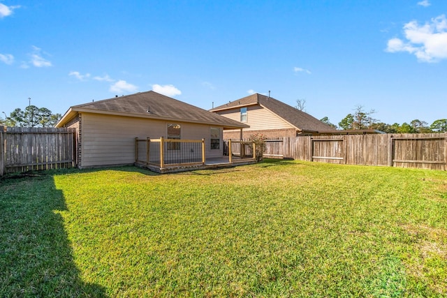 back of property with a lawn and a wooden deck