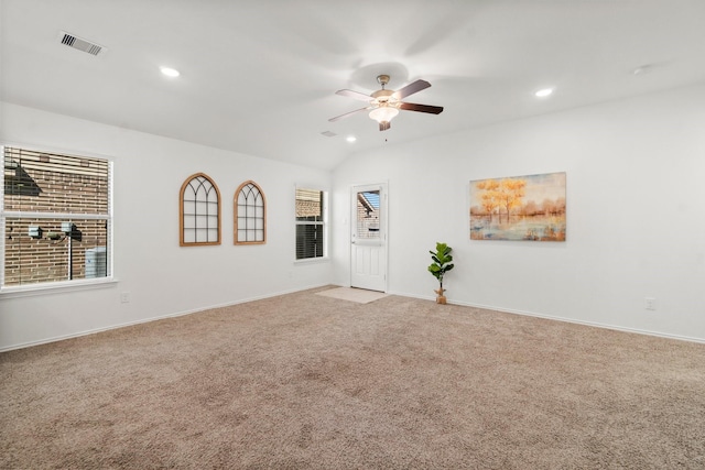 unfurnished room featuring a healthy amount of sunlight, light colored carpet, ceiling fan, and lofted ceiling