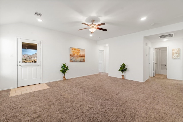 carpeted spare room featuring vaulted ceiling and ceiling fan