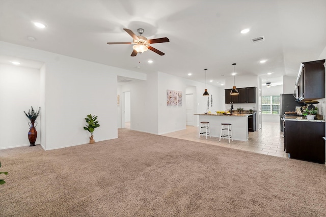 carpeted living room with ceiling fan