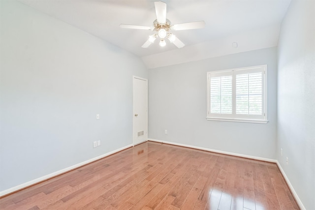 empty room featuring ceiling fan, light hardwood / wood-style floors, and vaulted ceiling