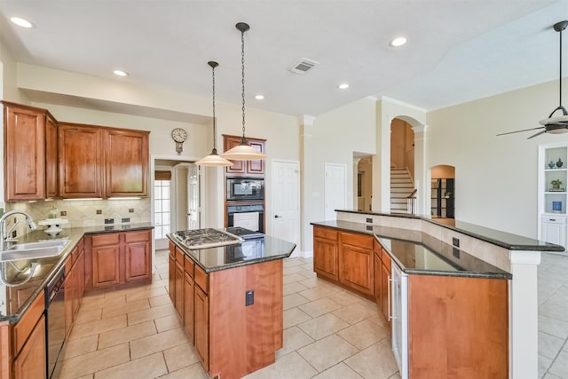 kitchen featuring sink, a center island, decorative light fixtures, and black appliances