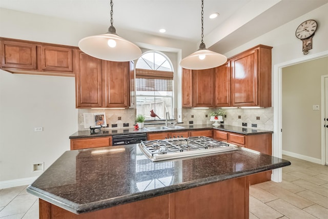 kitchen featuring decorative backsplash, decorative light fixtures, dark stone countertops, and sink