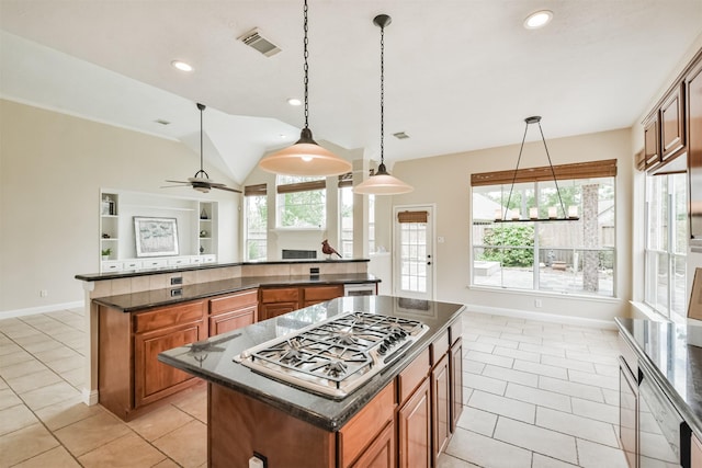 kitchen featuring a center island, hanging light fixtures, ceiling fan, light tile patterned floors, and stainless steel gas cooktop