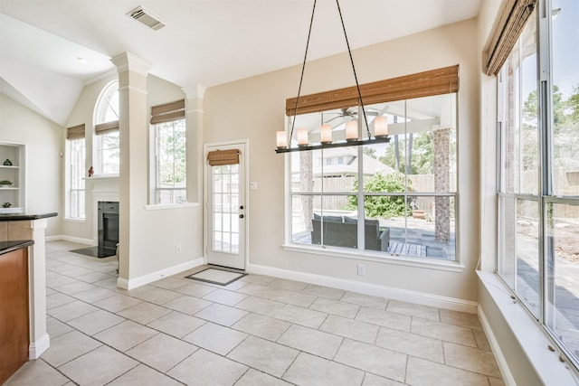 unfurnished dining area with plenty of natural light, light tile patterned flooring, and lofted ceiling