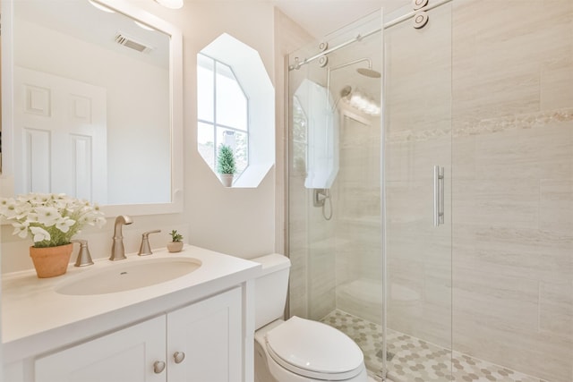 bathroom featuring vanity, toilet, and an enclosed shower