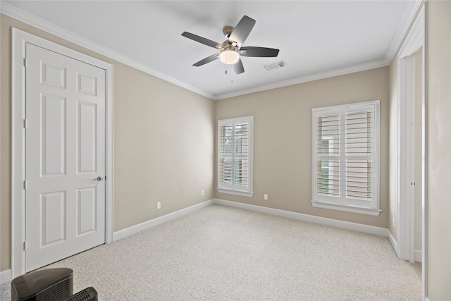 unfurnished bedroom featuring light carpet, ceiling fan, and crown molding