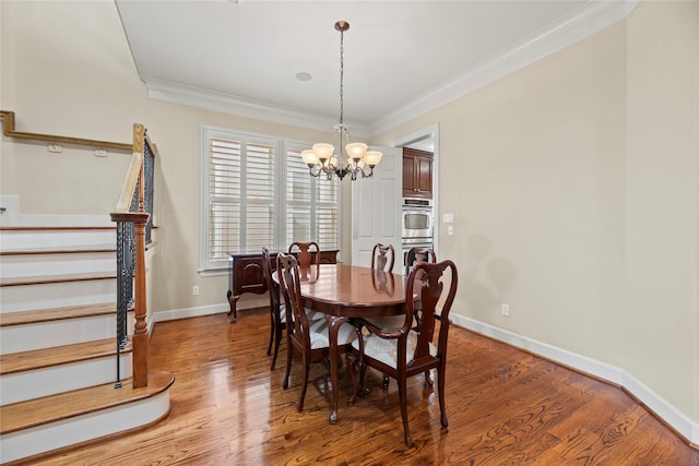 dining area featuring hardwood / wood-style flooring, a notable chandelier, and ornamental molding