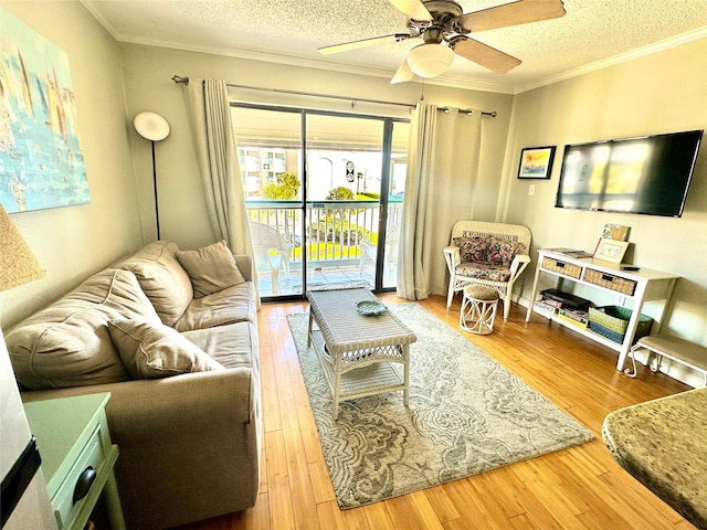 living room featuring crown molding, ceiling fan, hardwood / wood-style floors, and a textured ceiling