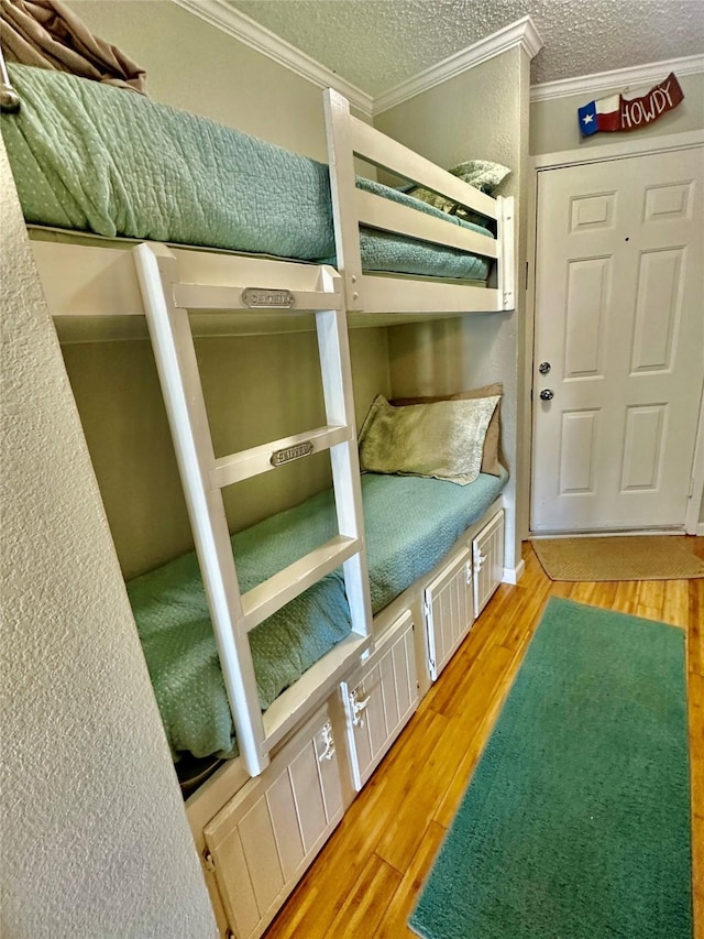 unfurnished bedroom with hardwood / wood-style flooring, crown molding, and a textured ceiling