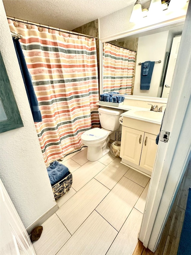 bathroom featuring vanity, toilet, and a textured ceiling