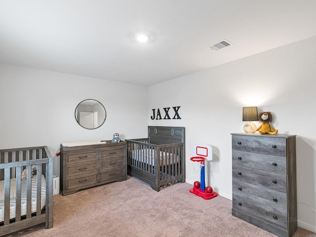 carpeted bedroom featuring a nursery area