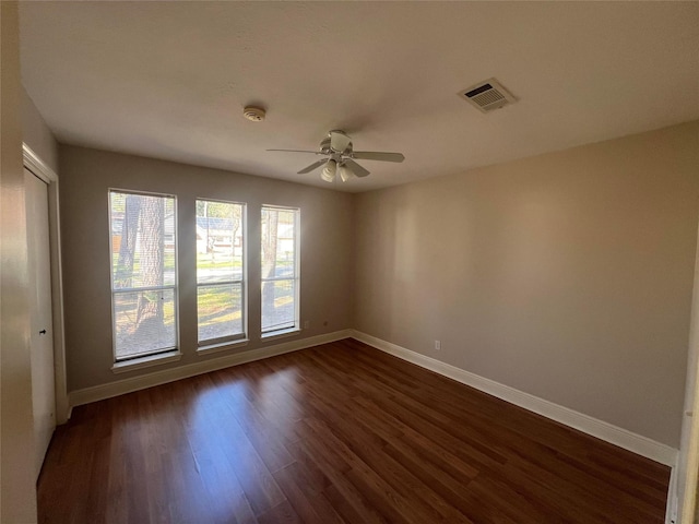 empty room featuring ceiling fan and dark wood-type flooring