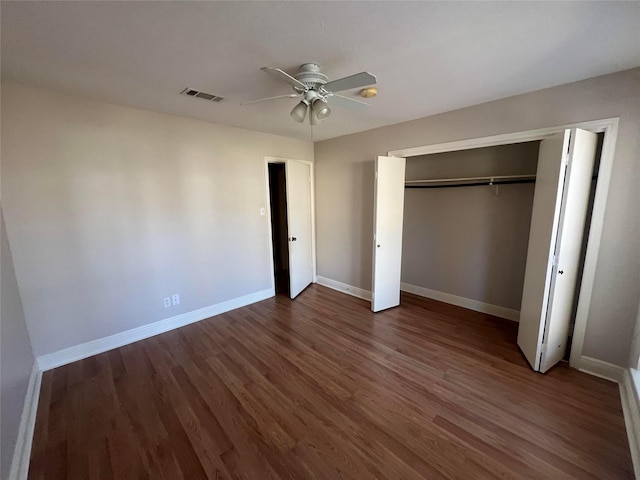 unfurnished bedroom featuring ceiling fan, dark hardwood / wood-style floors, and a closet