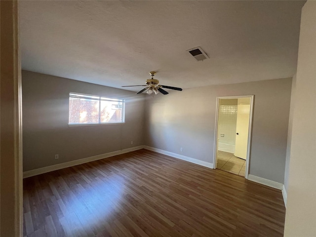 spare room featuring ceiling fan and dark wood-type flooring