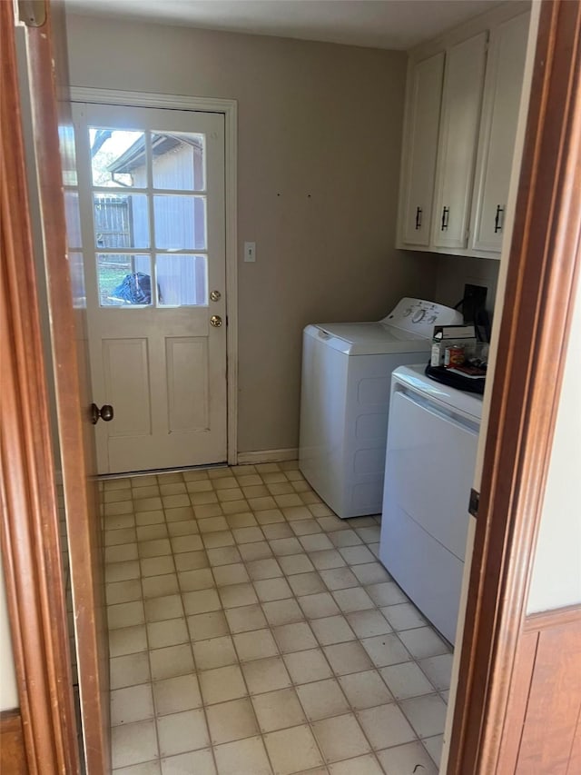 laundry area with washing machine and dryer and cabinets