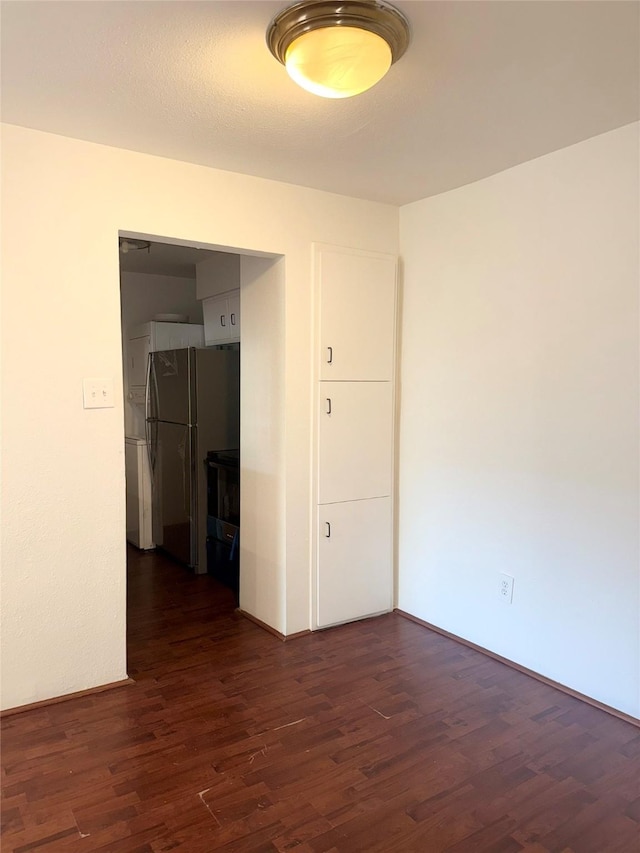 empty room with dark hardwood / wood-style flooring