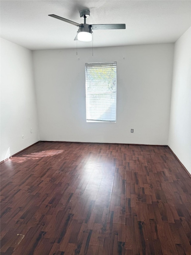 spare room with ceiling fan and dark wood-type flooring