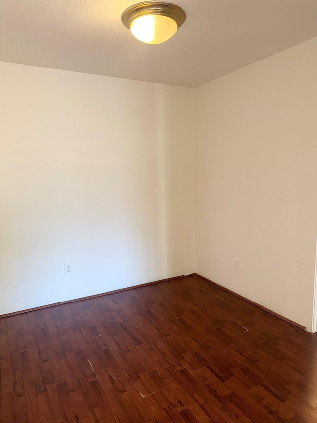 empty room with dark wood-type flooring