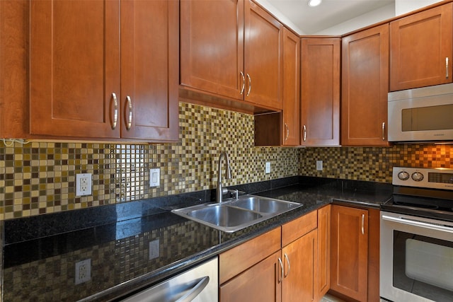 kitchen with tasteful backsplash, sink, dark stone counters, and appliances with stainless steel finishes