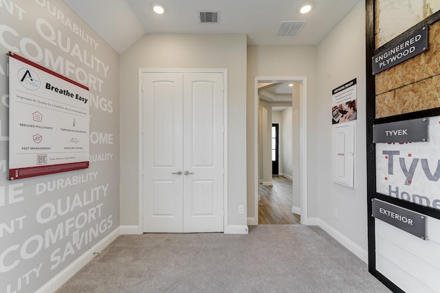 hallway with carpet floors, baseboards, and visible vents