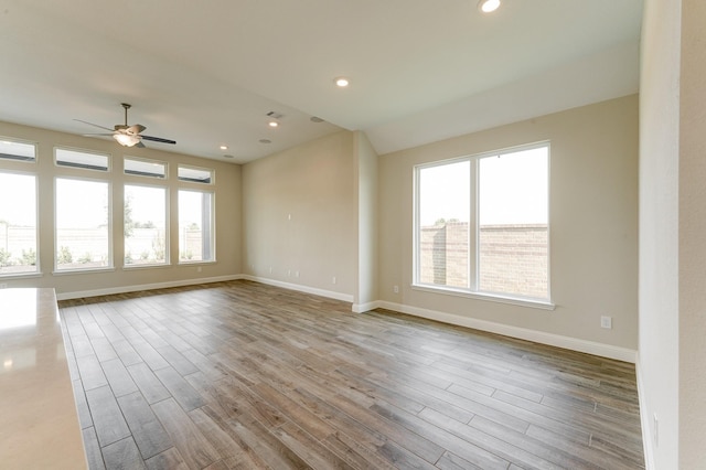 unfurnished room with recessed lighting, wood finished floors, and baseboards