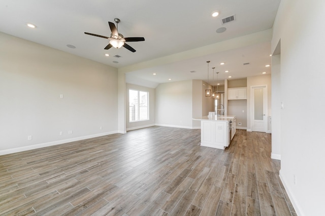 unfurnished living room featuring ceiling fan, recessed lighting, visible vents, baseboards, and light wood finished floors