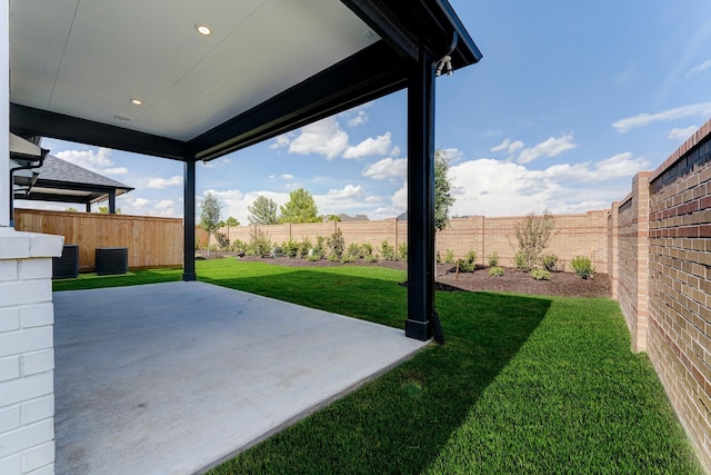 view of yard featuring a patio area, a fenced backyard, and central AC unit