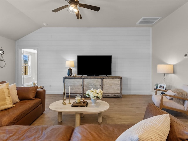 living room featuring lofted ceiling, ceiling fan, and light wood-type flooring