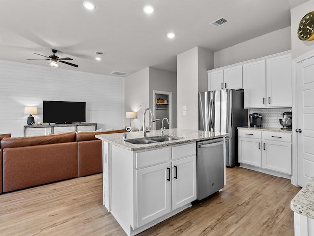 kitchen with stainless steel dishwasher, white cabinetry, and sink