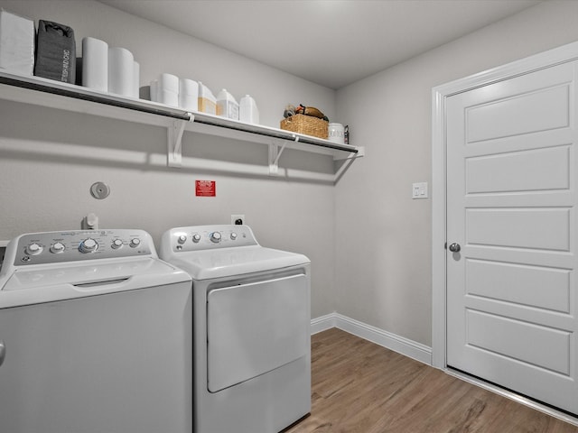 clothes washing area featuring washer and clothes dryer and hardwood / wood-style flooring