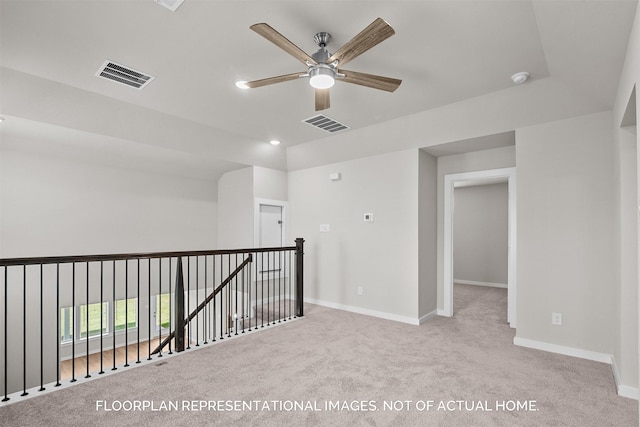 carpeted spare room featuring ceiling fan