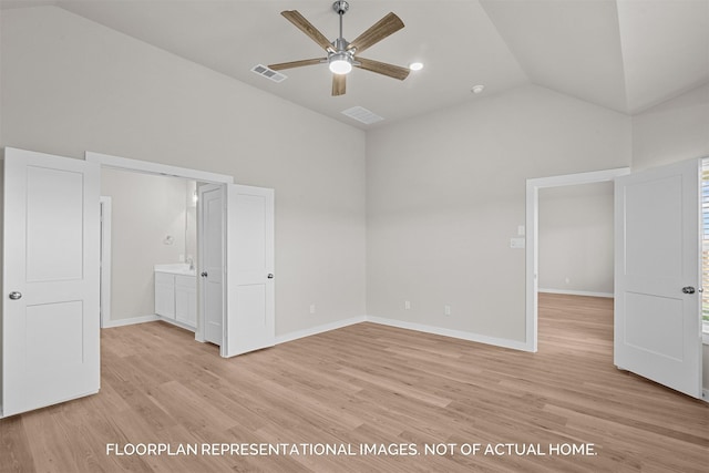 unfurnished bedroom featuring ceiling fan, light hardwood / wood-style floors, ensuite bathroom, and vaulted ceiling