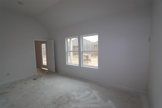 spare room with baseboards and lofted ceiling