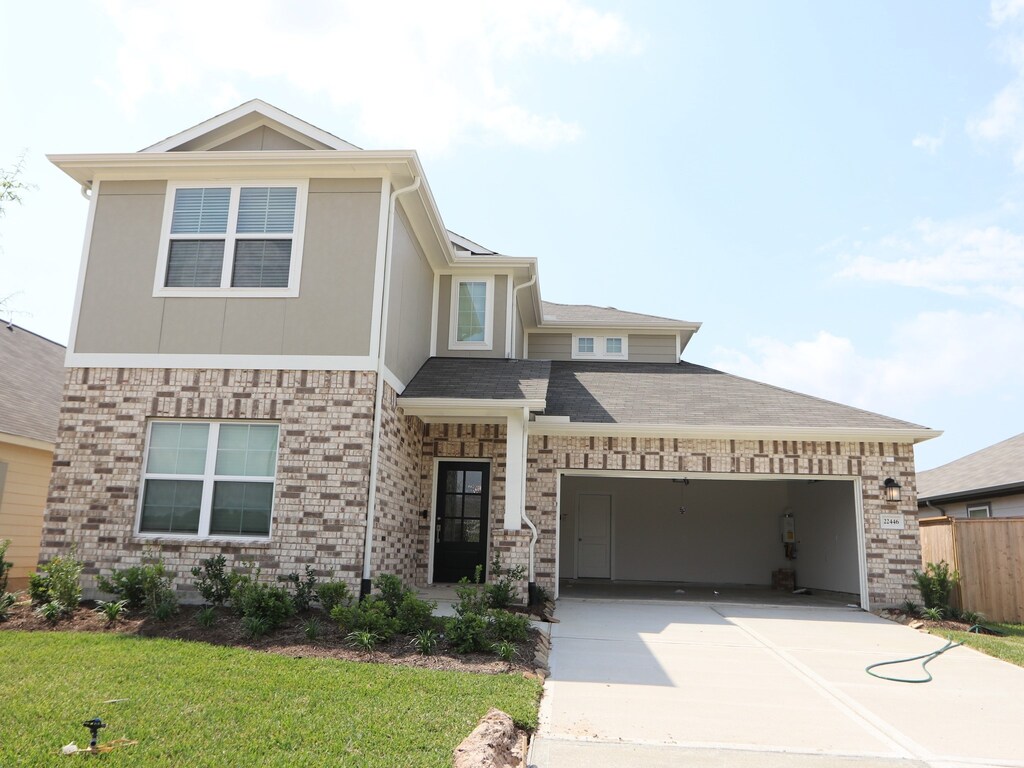 22446 Birchfield Grove Ln, New Caney, TX 77357 - view of front of home with an attached garage, driveway, a front yard, and fence